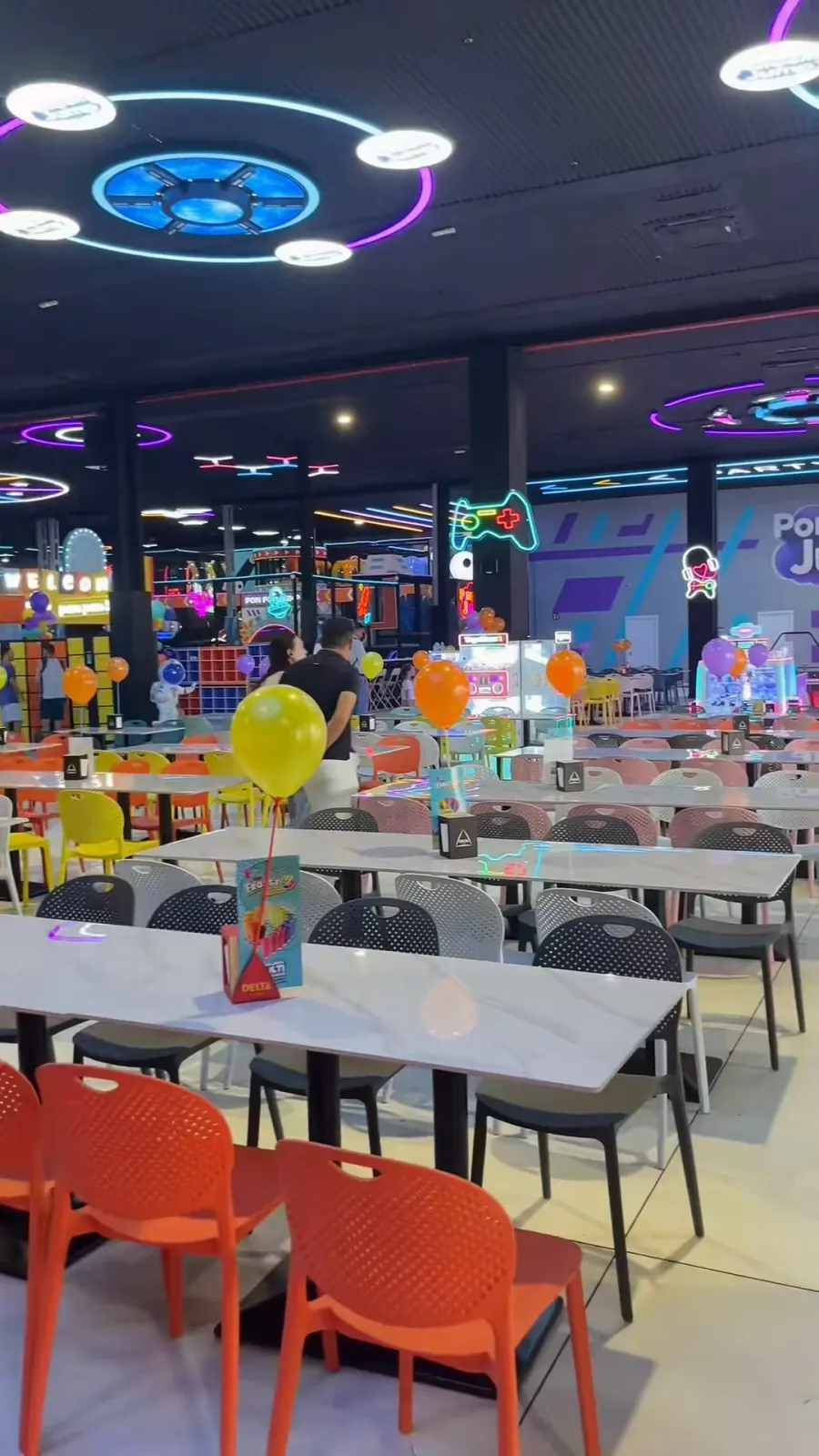 Zona de mesas y cafetería del parque decorada con globos